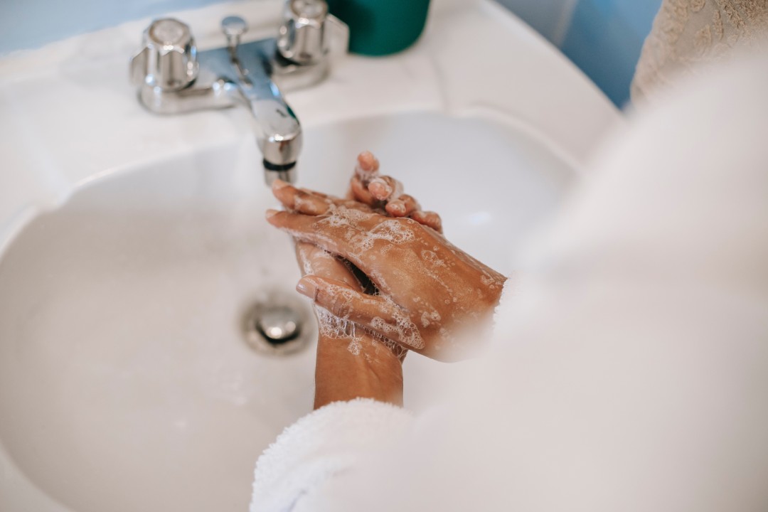 hands being washed in a toilet sink