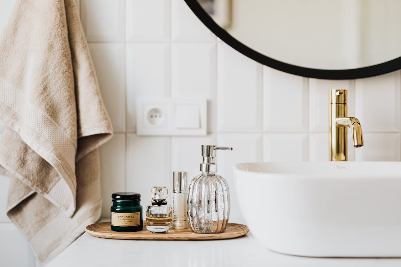 bathroom sink area with bowl-shaped, white sink and toiletries