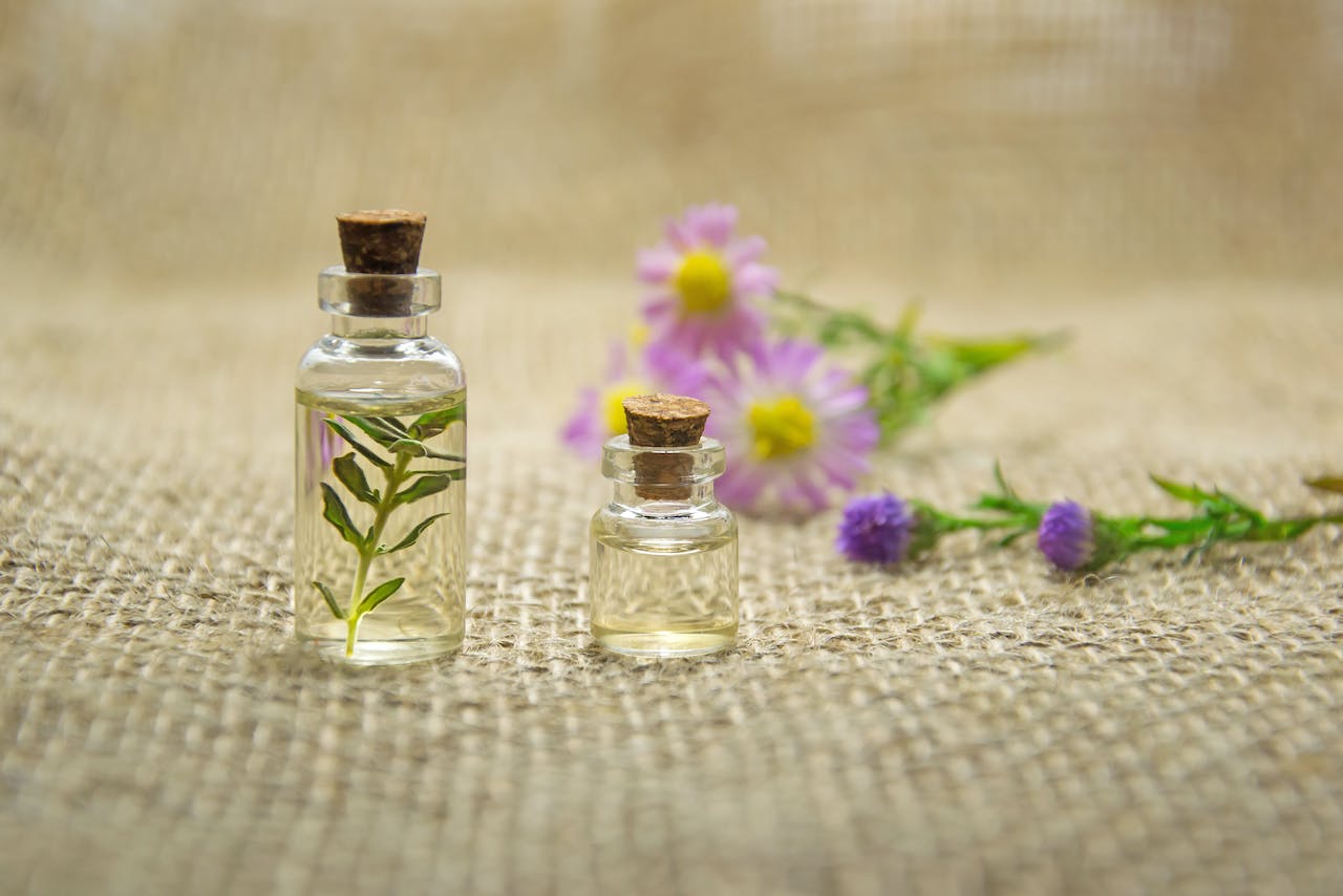 tiny glass bottles with flowers scatterd around them